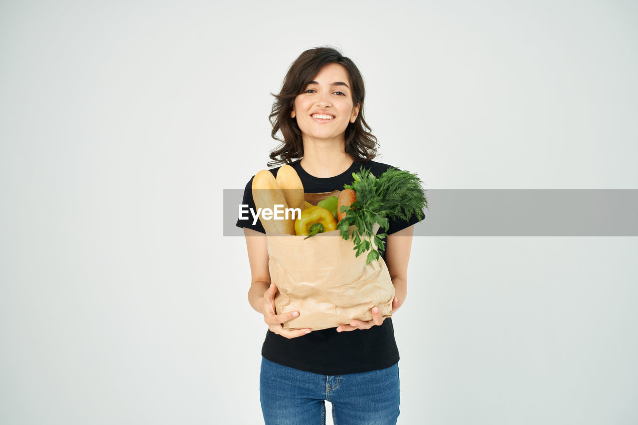 Portrait of smiling young woman against white background