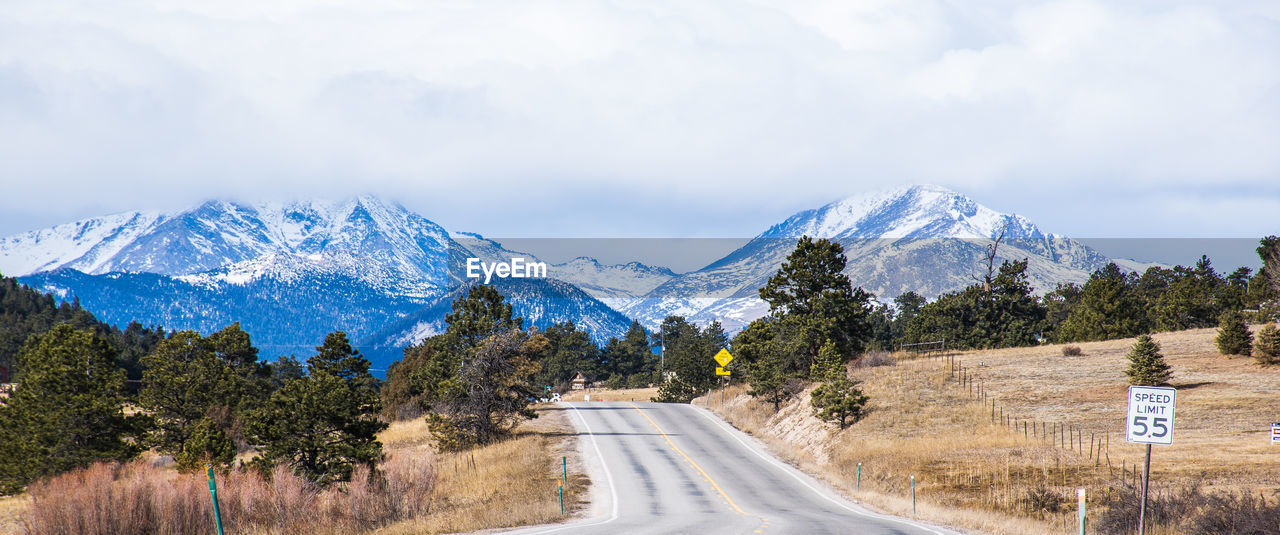 ROAD PASSING THROUGH MOUNTAINS AGAINST SKY