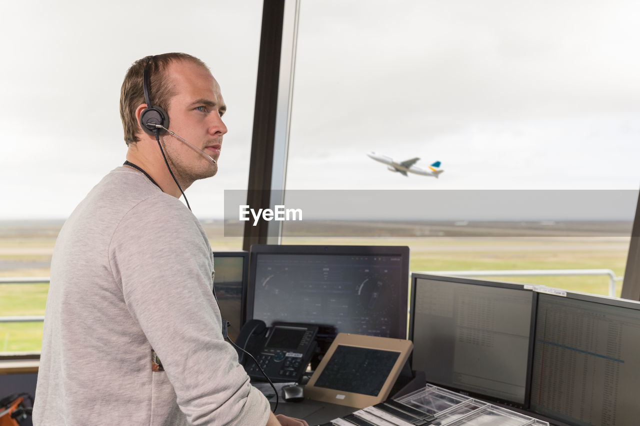 Male dispatcher controlling flights in airport