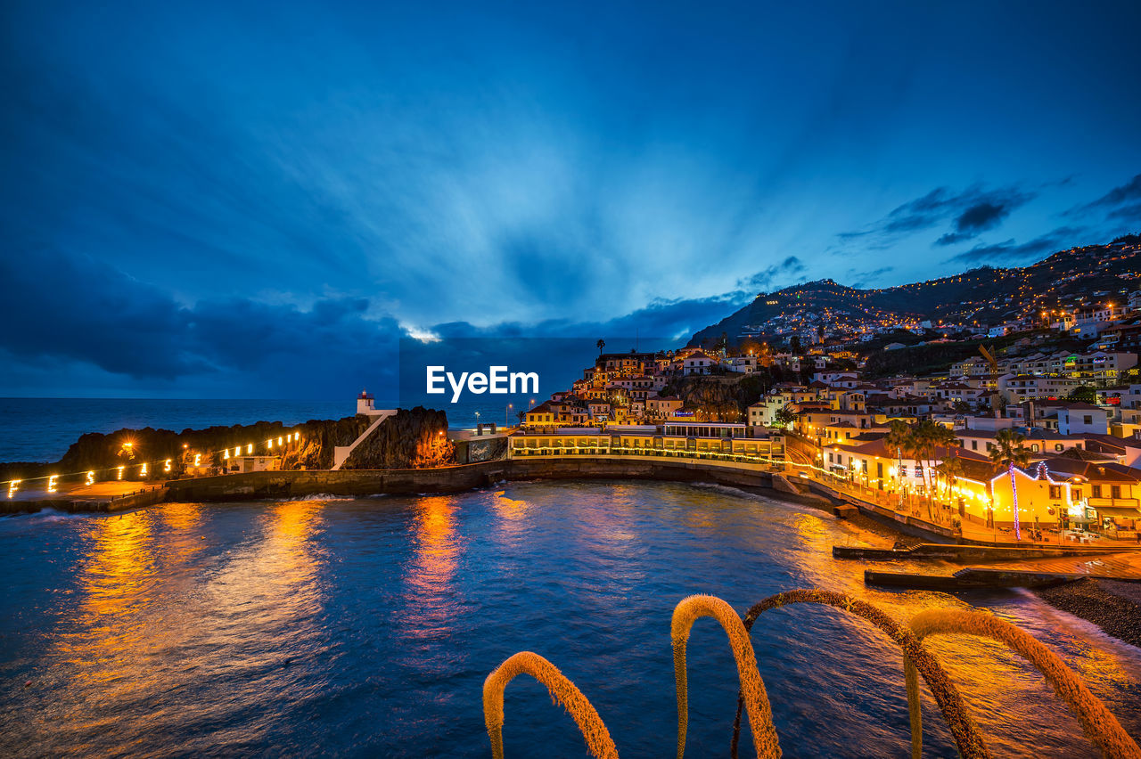 scenic view of illuminated buildings against sky at night