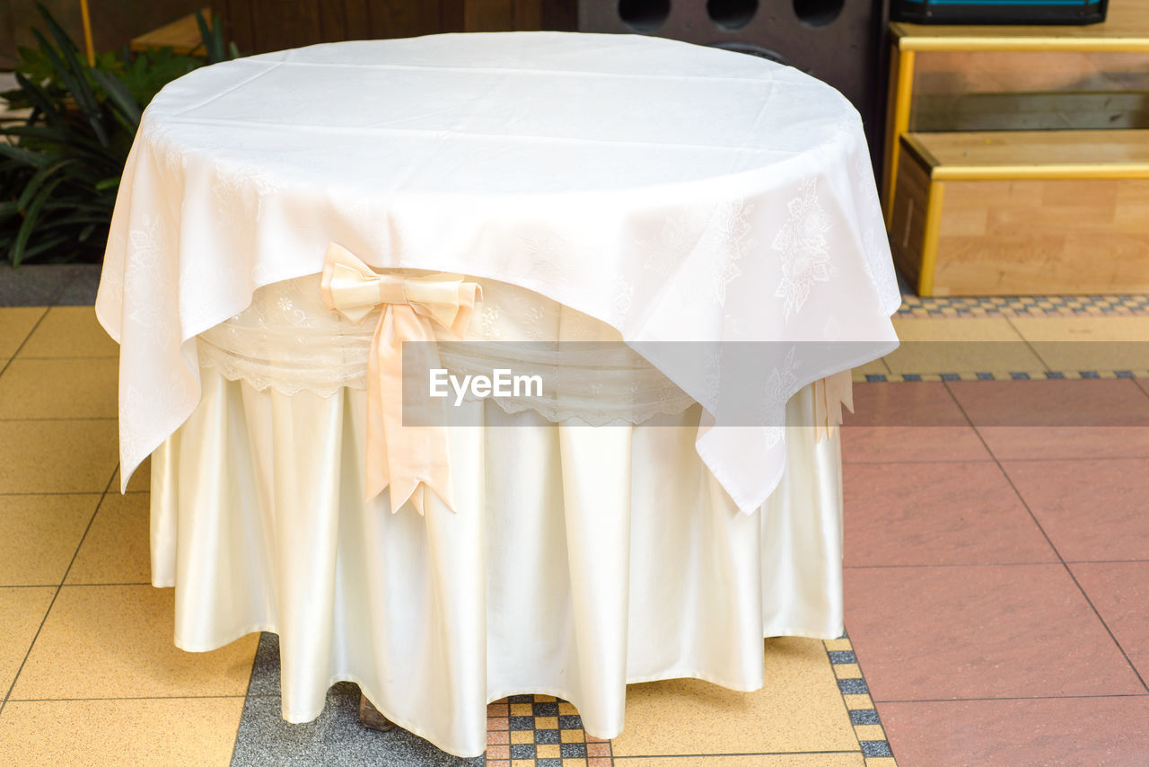 wedding, white, furniture, flooring, celebration, event, table, clothing, tablecloth, indoors, seat, life events, no people, tiled floor, textile, chair, tile, fashion, elegance, wedding dress, wedding ceremony, wealth, luxury