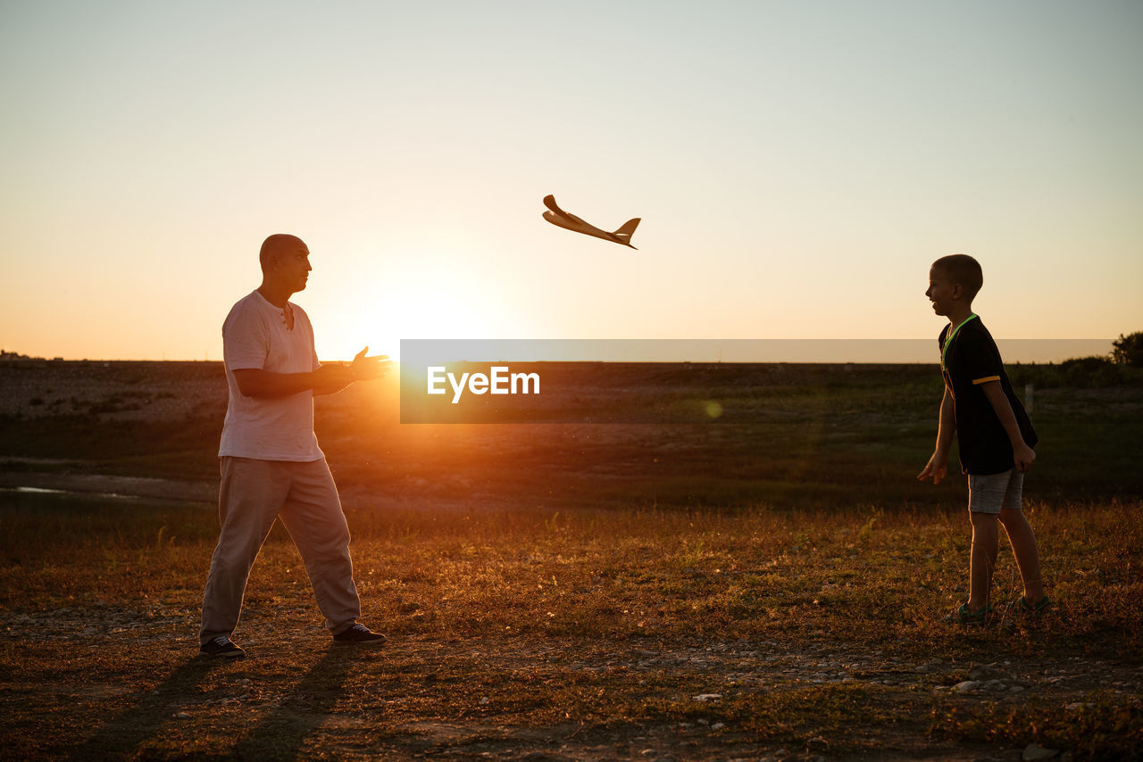 Soft focus of father and son playing toy airplane