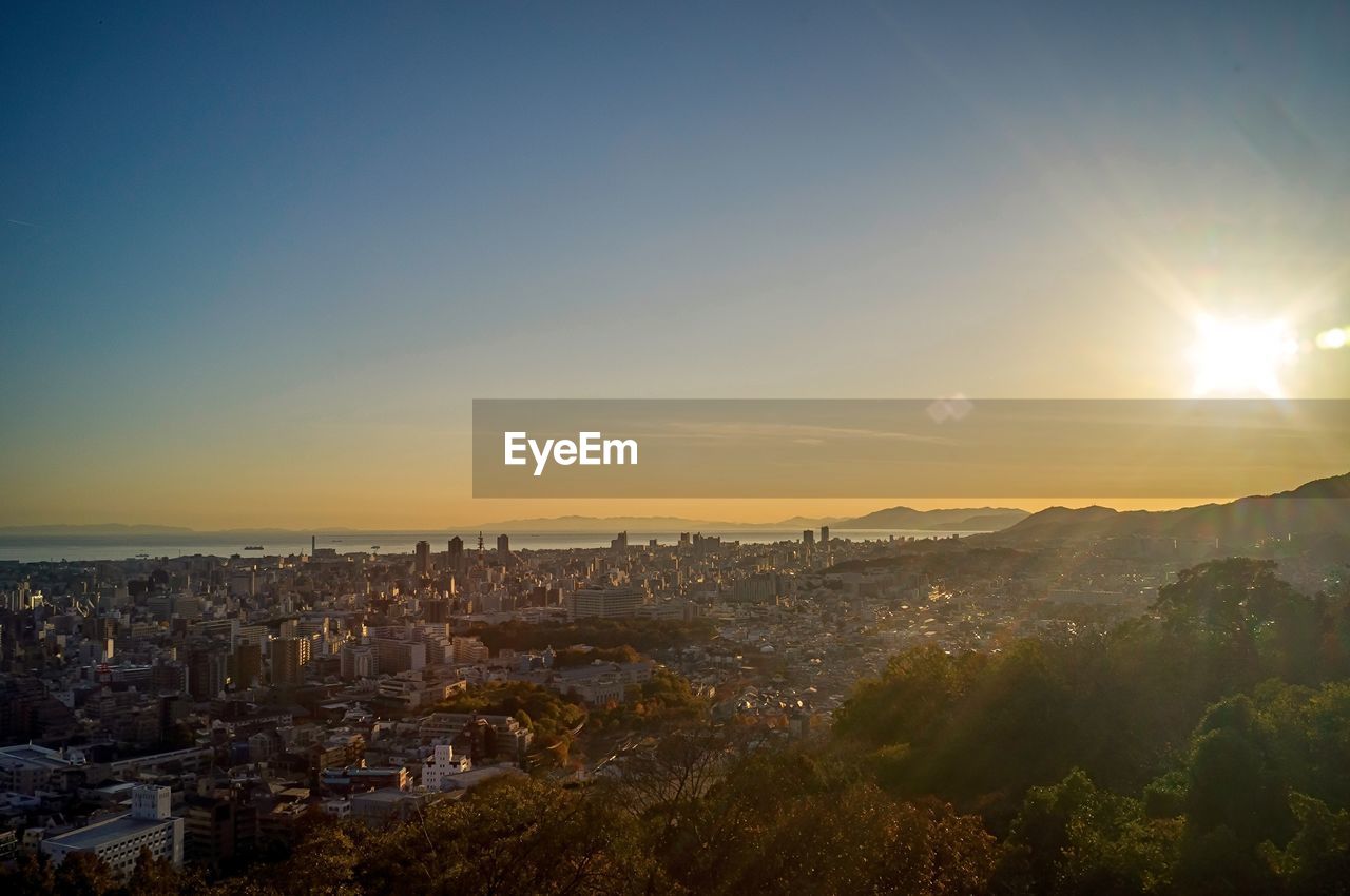 Aerial view of cityscape against clear sky during sunset