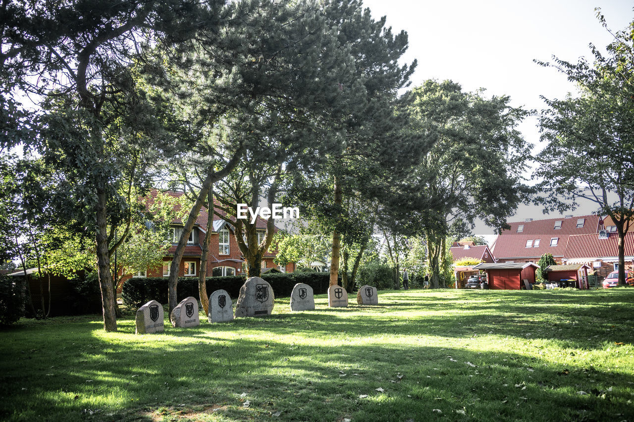 plant, tree, grass, architecture, nature, built structure, estate, green, day, building exterior, no people, building, cemetery, grave, sky, lawn, growth, park, house, garden, outdoors, religion, tombstone, sunlight, death, history, the past, yard, tranquility