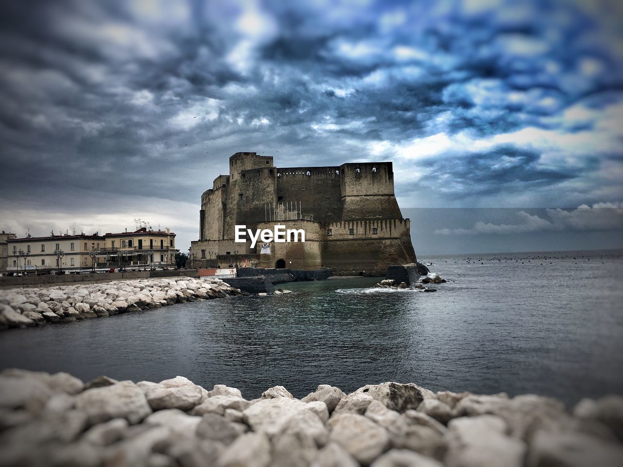 View of fort by sea against cloudy sky