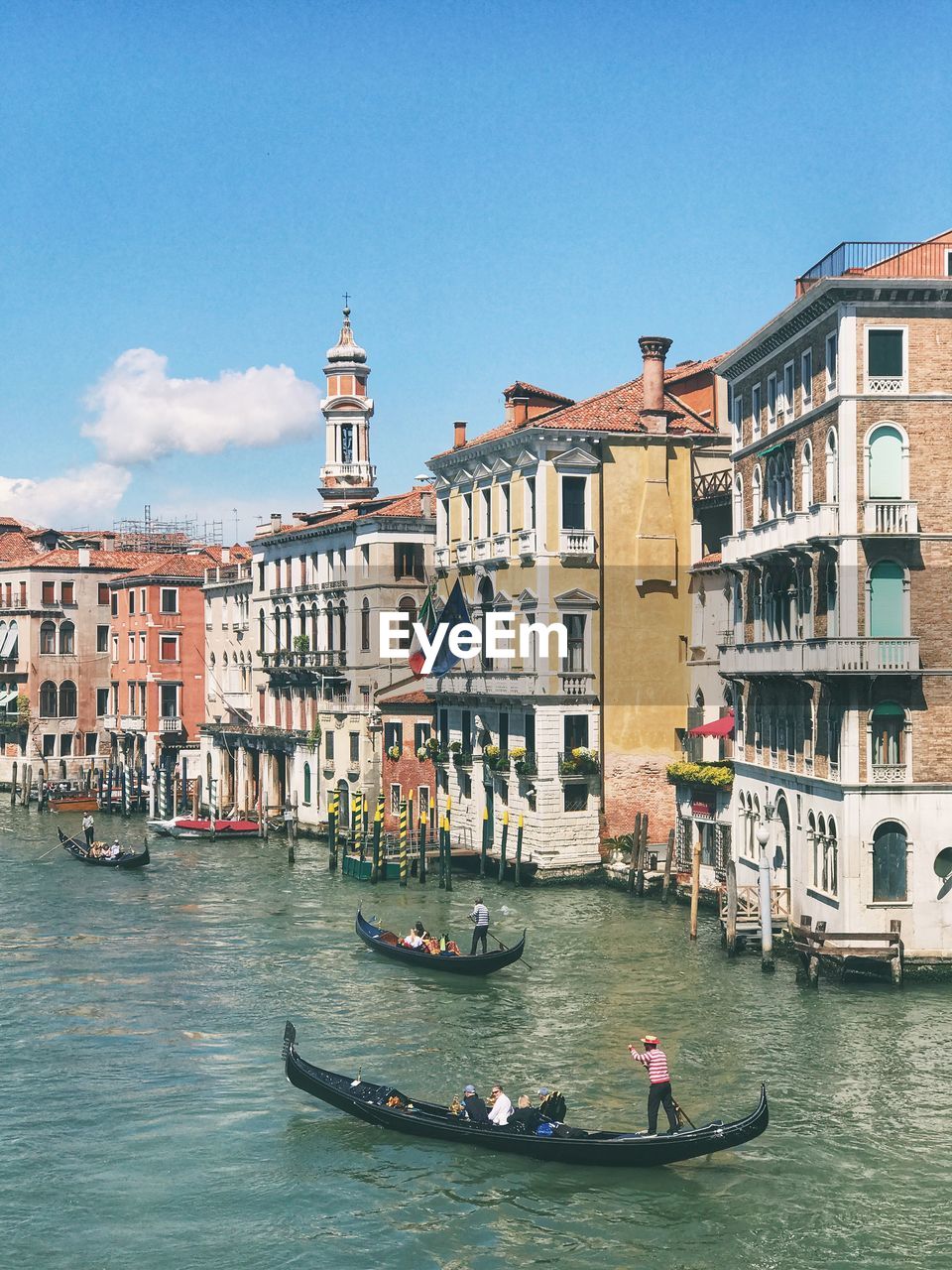 Boats in canal by buildings in city