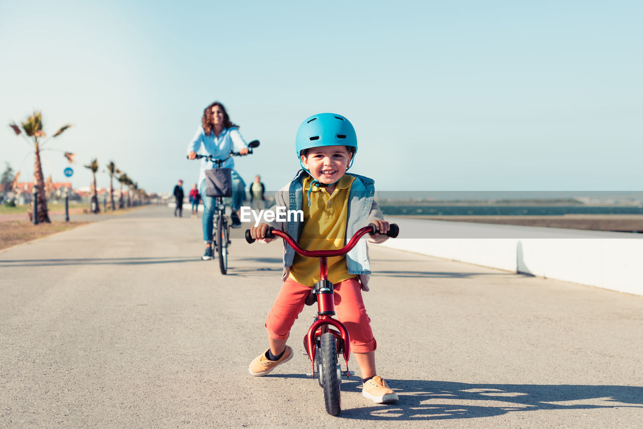 FULL LENGTH PORTRAIT OF BOY RIDING BICYCLE ON BEACH