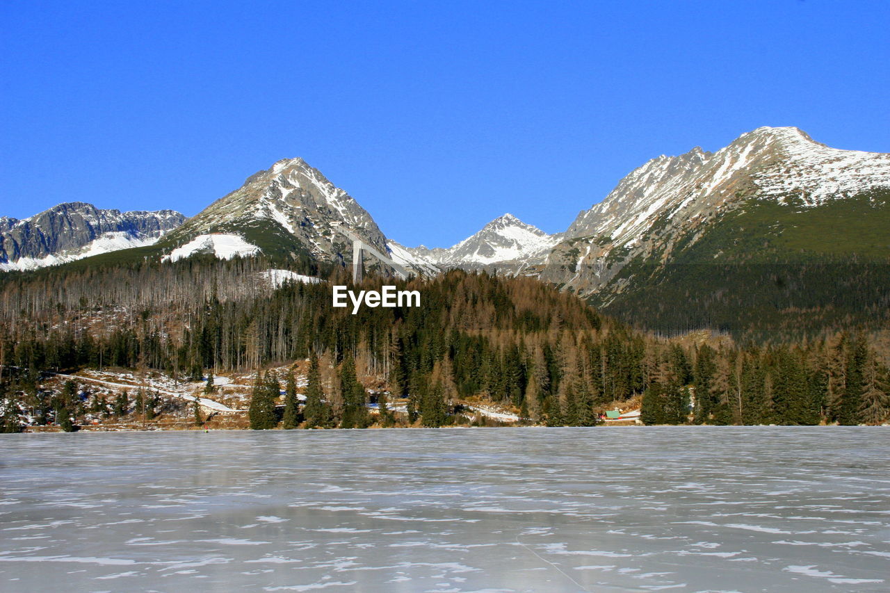 Scenic view of snow covered mountains against clear sky