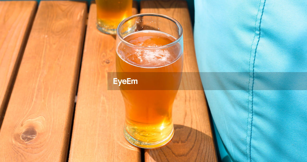 midsection of woman holding drink on table