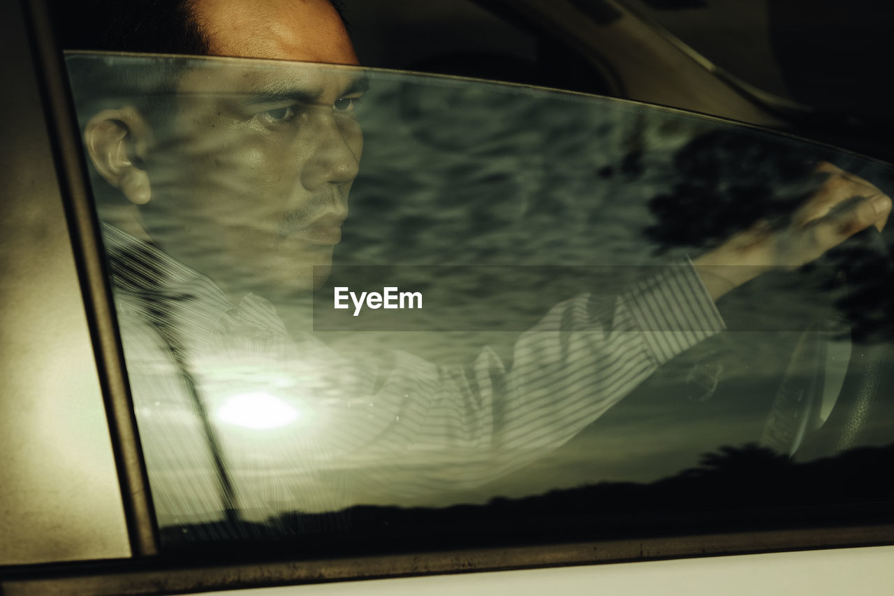 Man looking away while sitting in car