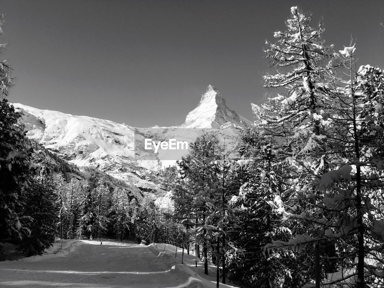 Scenic view of snow covered mountains against cloudy sky