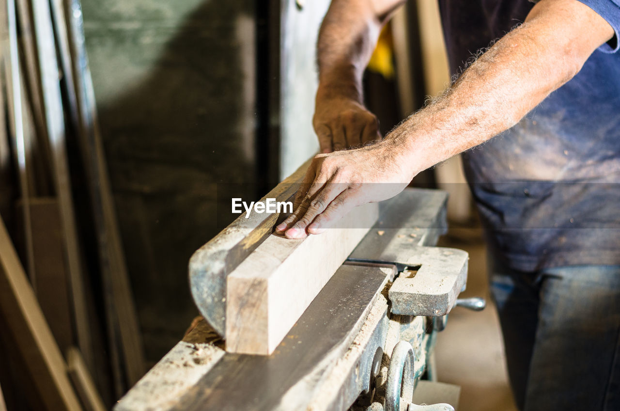 Midsection of carpenter working in workshop