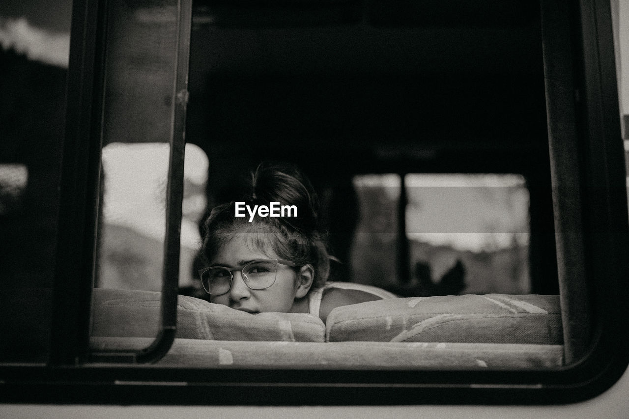 Portrait of girl seen through glass window