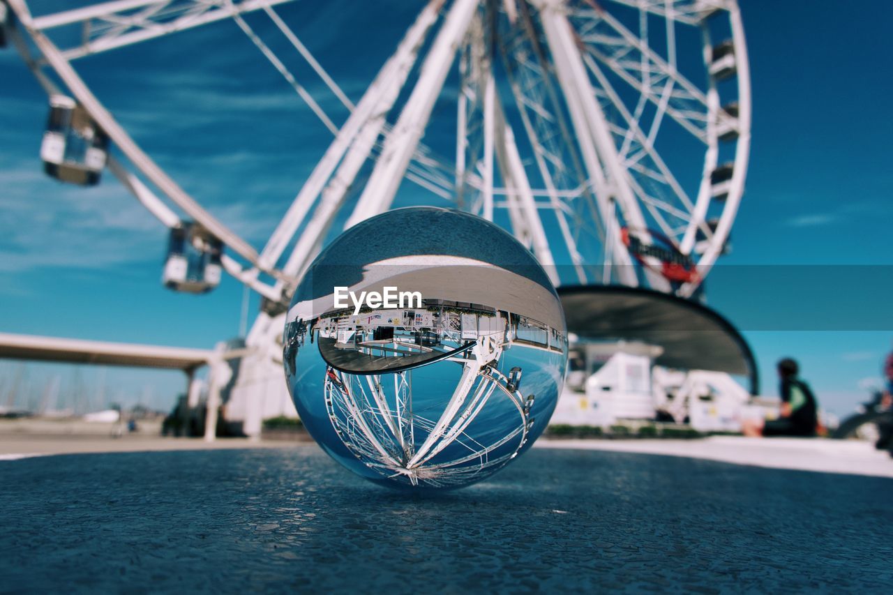 Low angle view of crystal ball against ferris wheel 