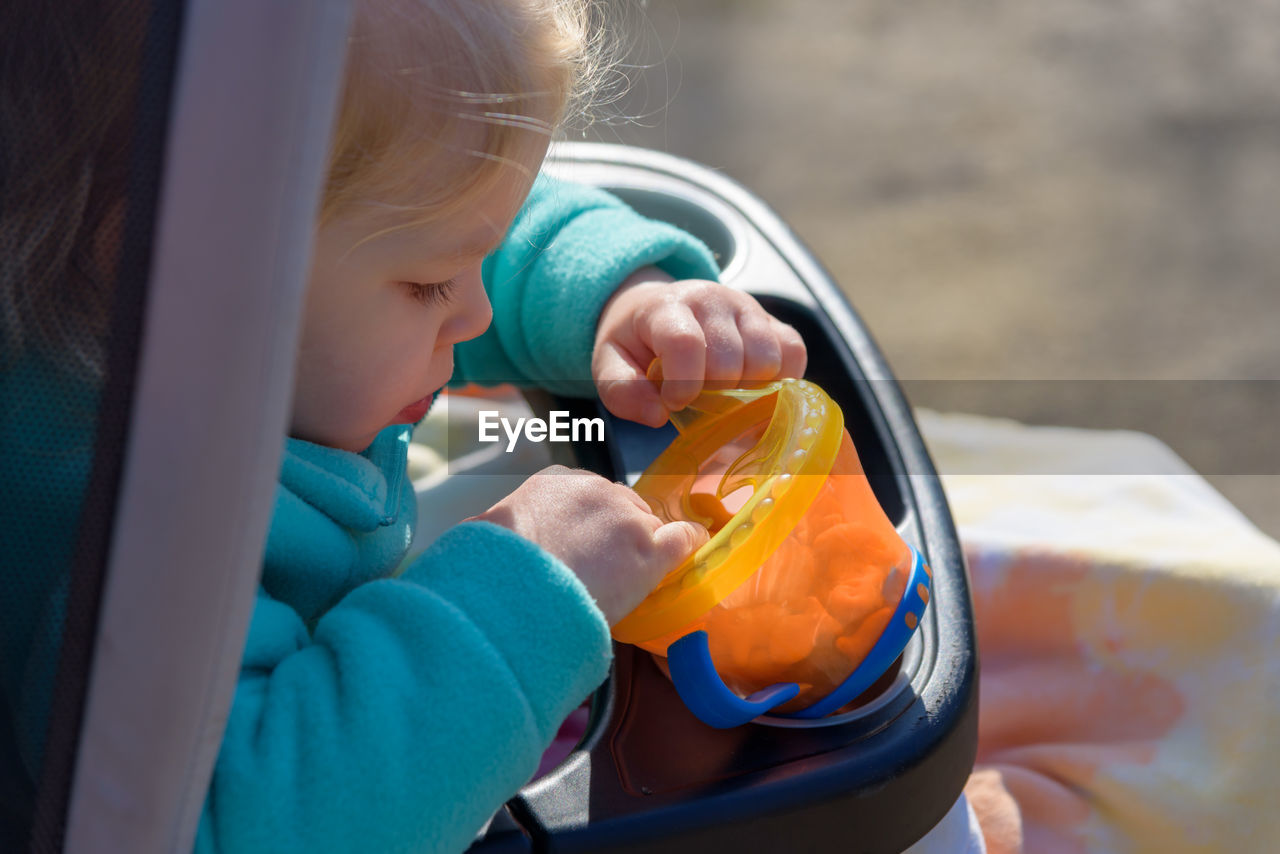 Side view of girl holding container