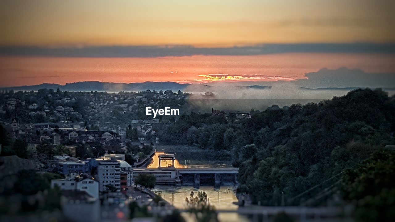 HIGH ANGLE SHOT OF TOWNSCAPE AGAINST SKY DURING SUNSET