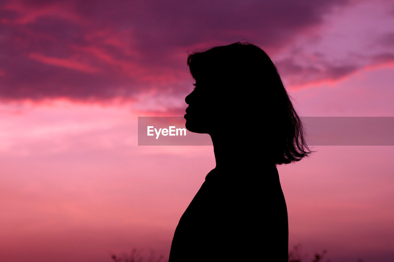 Nature and beauty concept. pink and orange sundown. girl silhouette at sunset