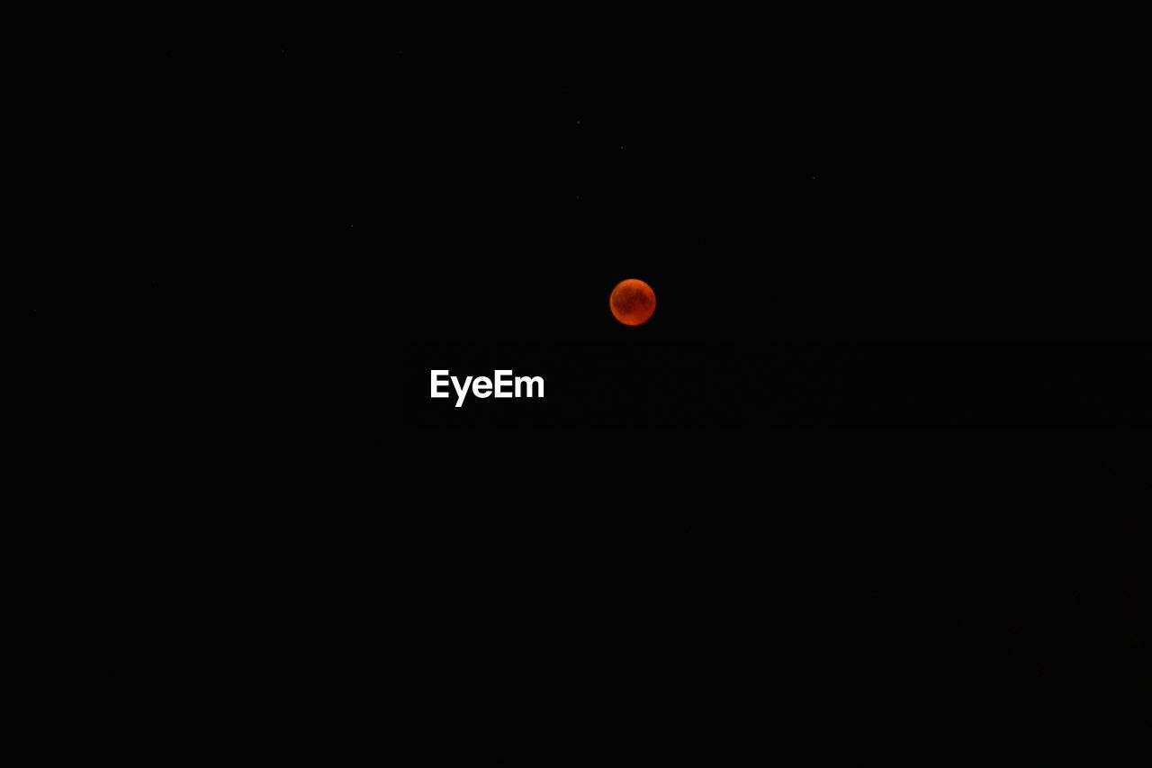 LOW ANGLE VIEW OF ORANGE MOON AGAINST SKY