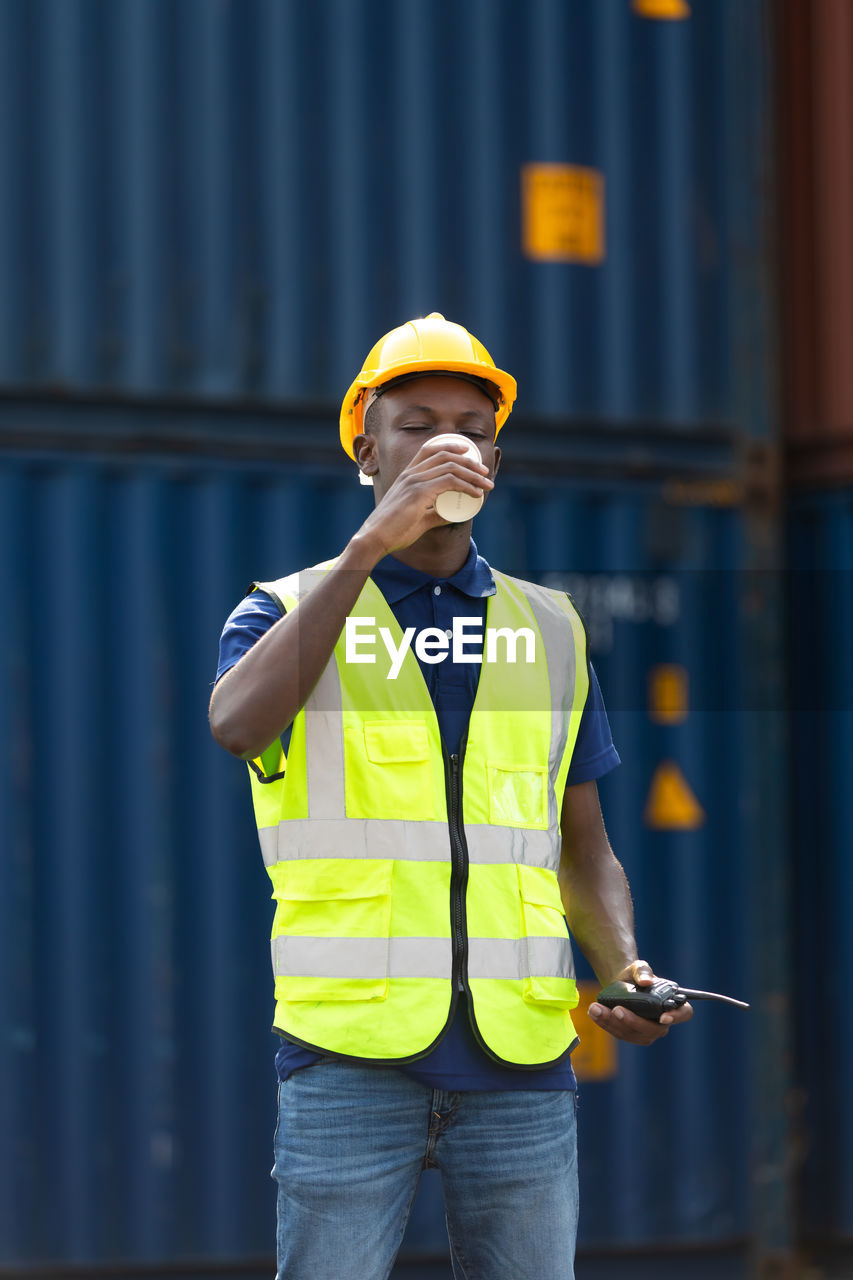 MAN WORKING WITH ARMS RAISED STANDING