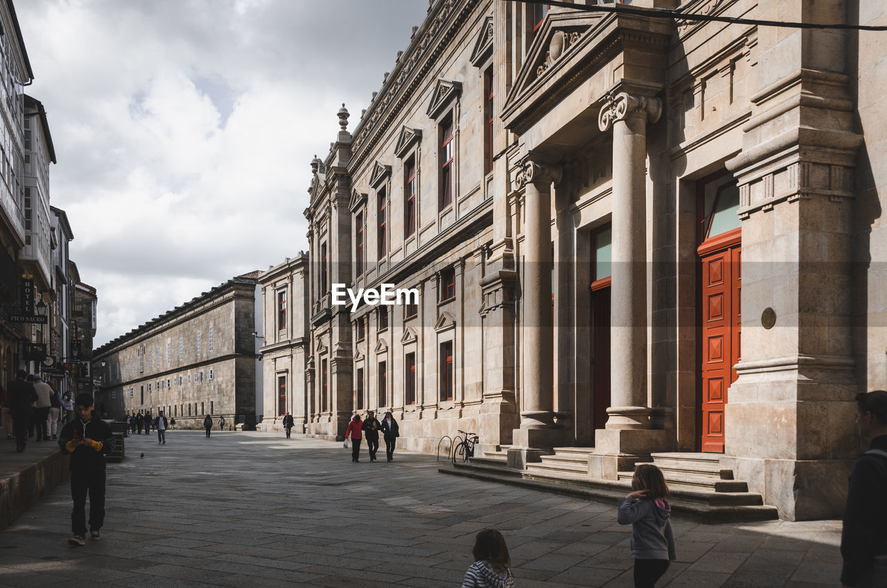 rear view of people walking in front of historic building