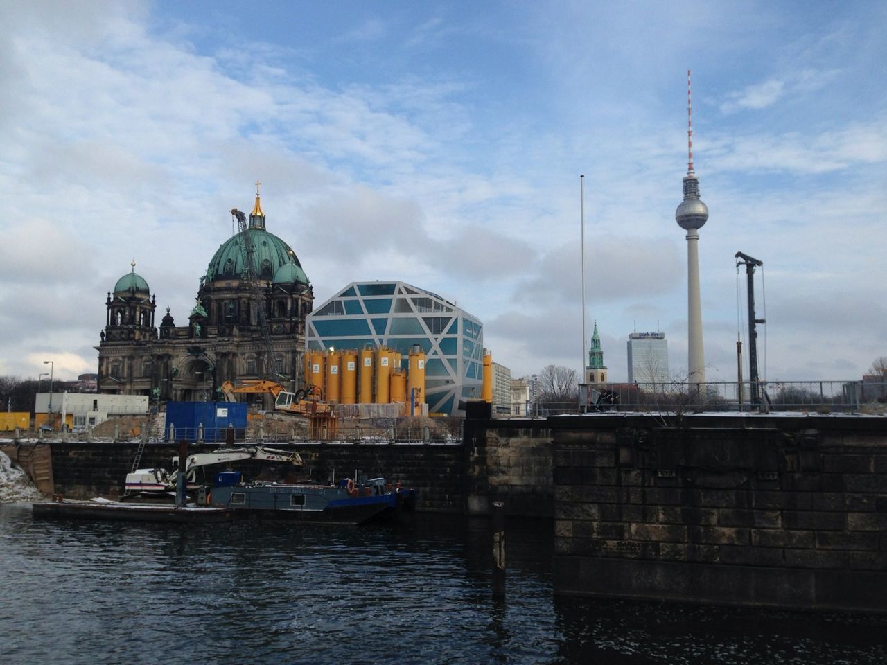 Berlin cathedral by fernsehturm tower and river against sky