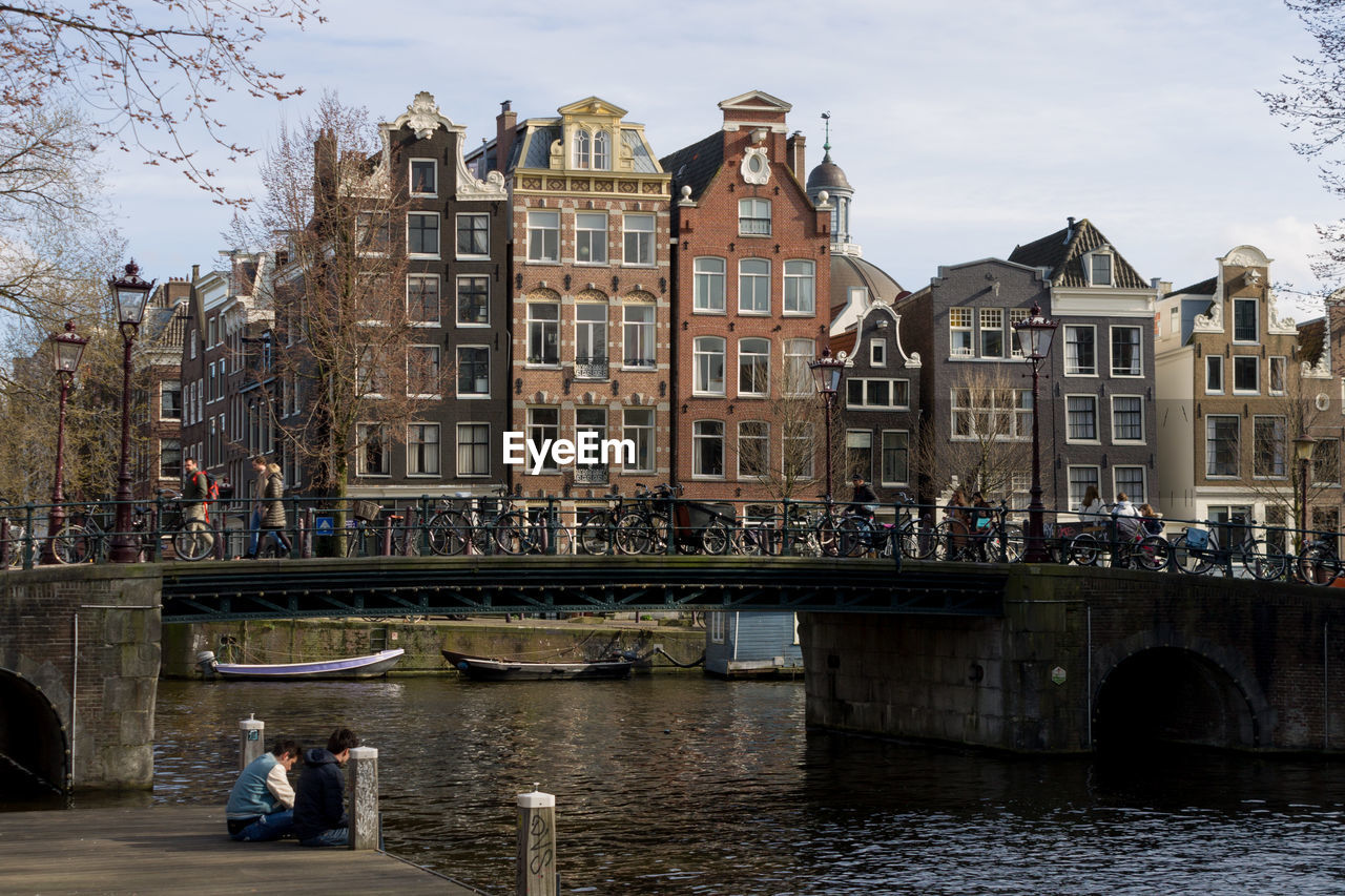 PEOPLE ON BRIDGE OVER CANAL