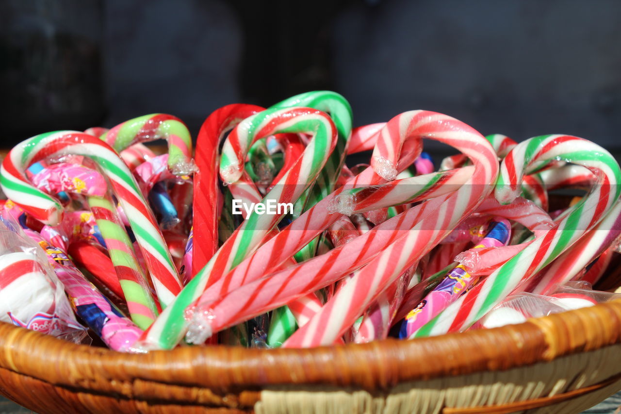 Close-up of multi colored candy canes in wicker basket