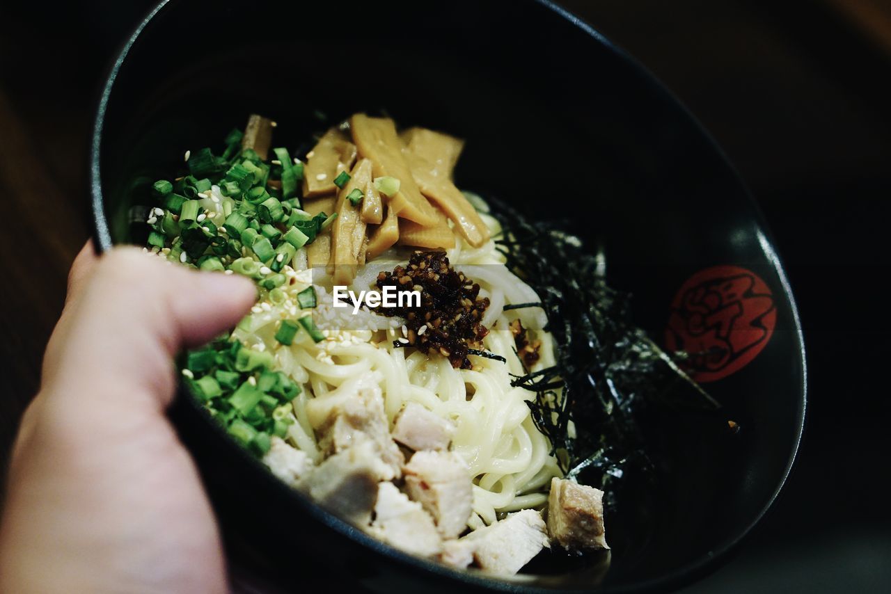 CLOSE-UP OF HAND HOLDING FOOD