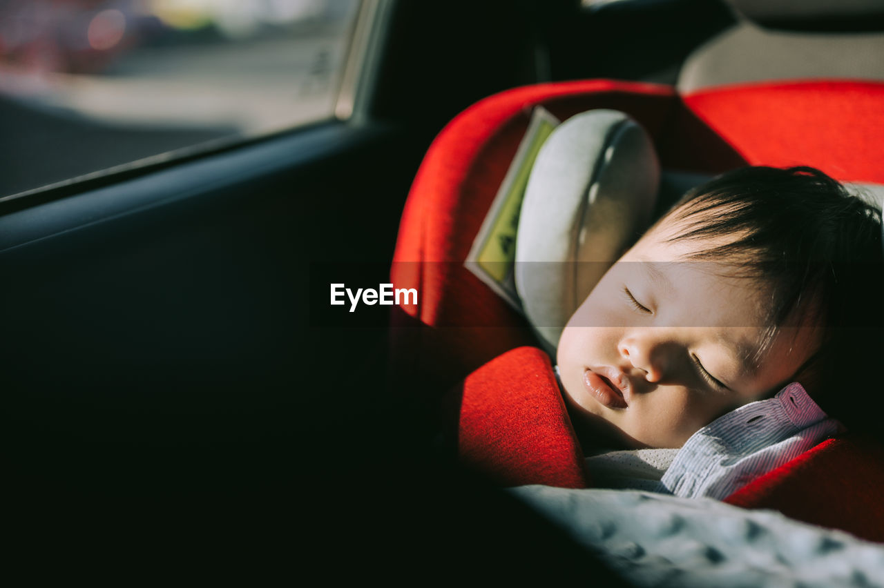 Cute boy sleeping in car