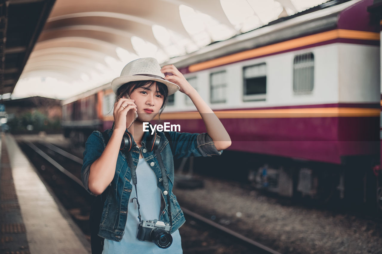 WOMAN IN TRAIN AT RAILROAD STATION PLATFORM