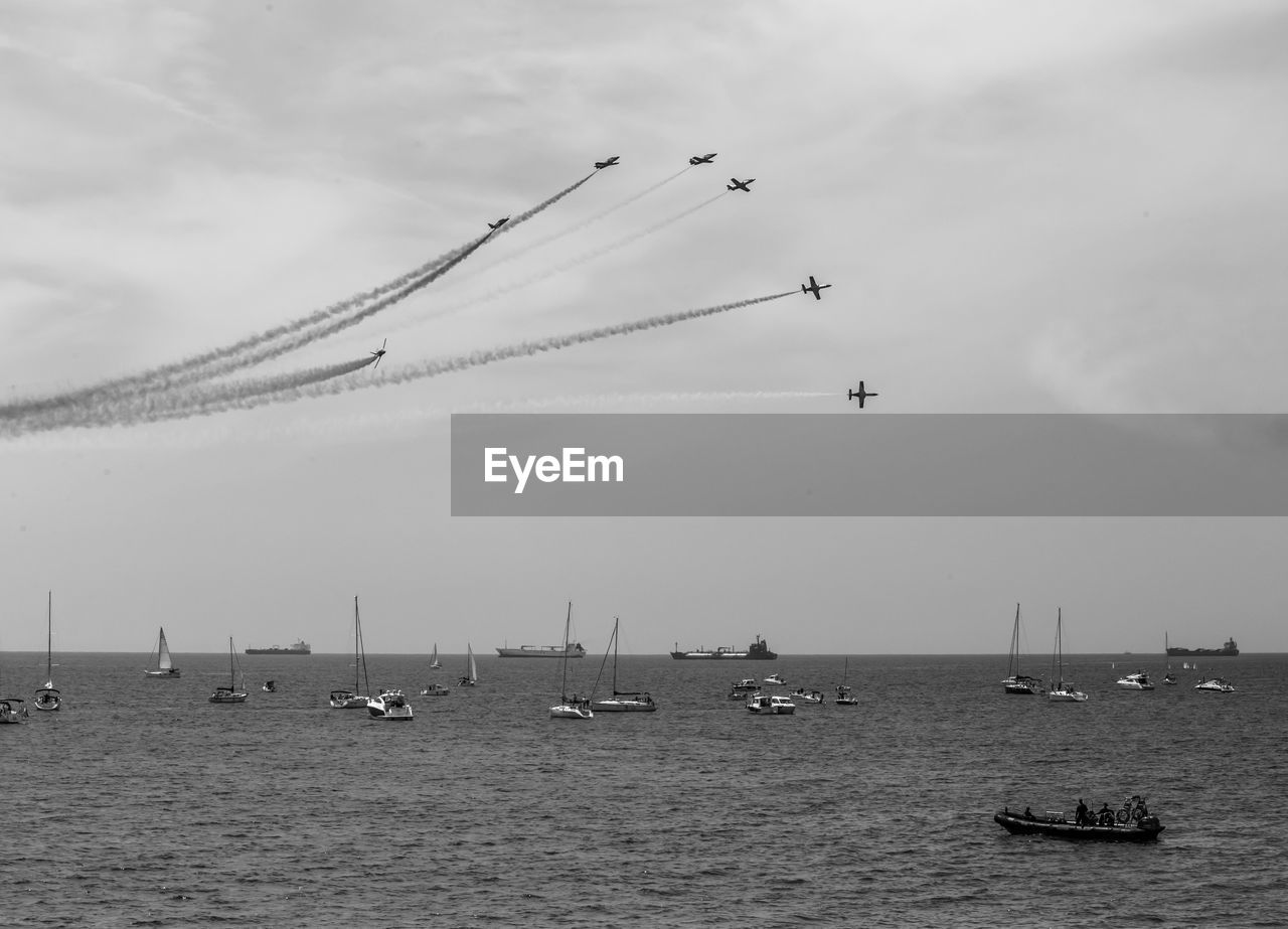 Sailboats in sea against sky