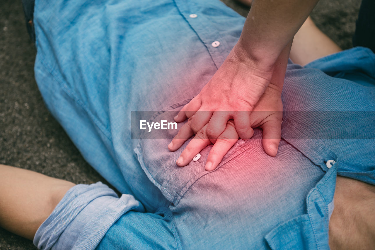 MIDSECTION OF MAN AND WOMAN SITTING AT SIDEWALK