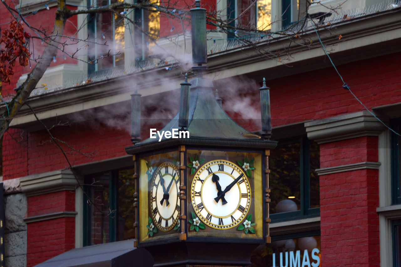 LOW ANGLE VIEW OF ILLUMINATED CLOCK TOWER