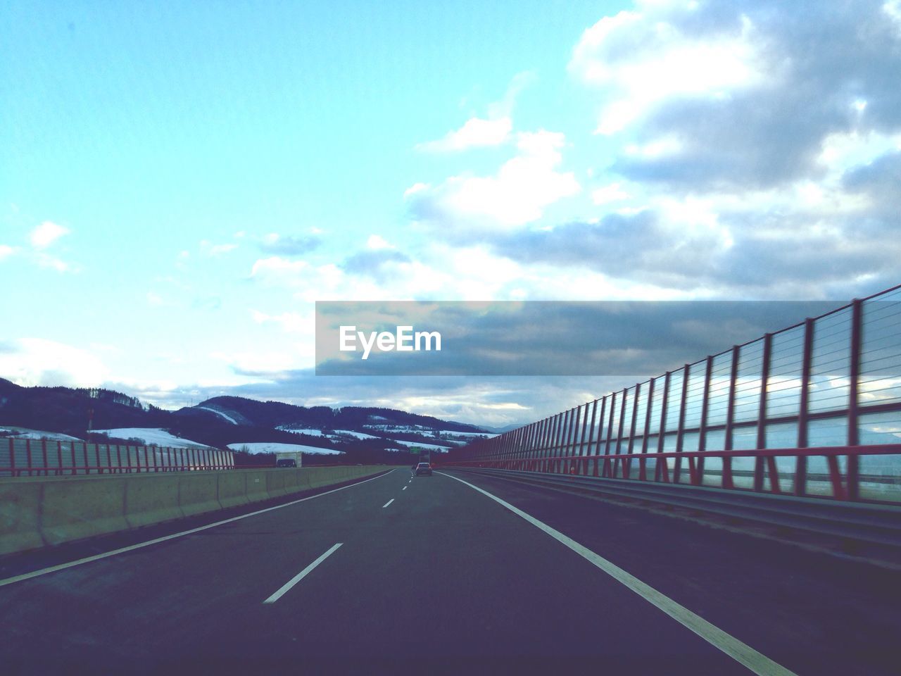 VIEW OF ROAD AGAINST CLOUDY SKY