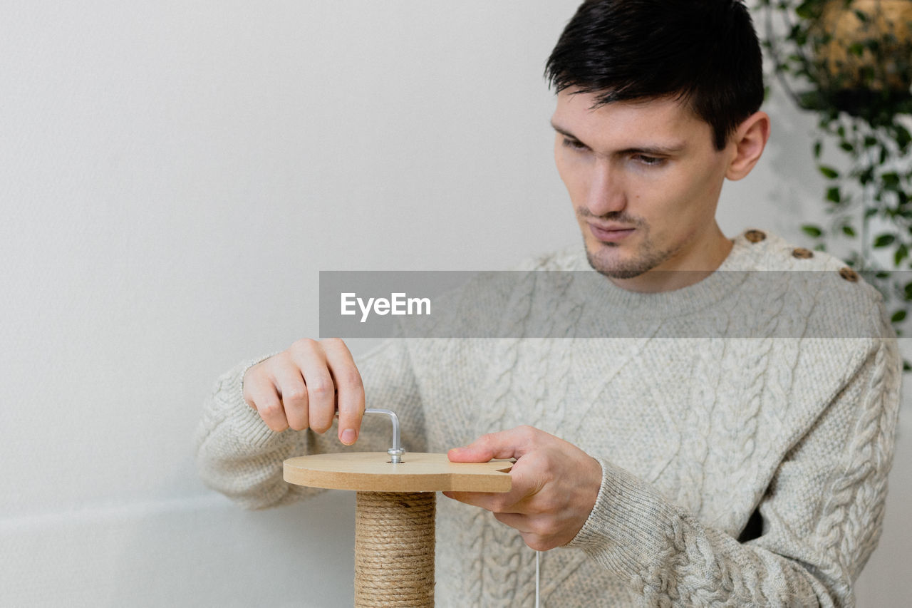 A young man collects a scratching post.