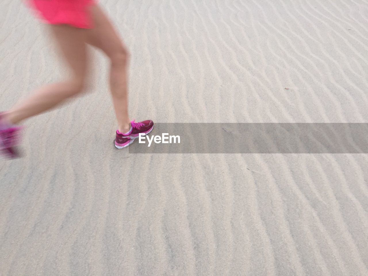 Low section of woman jogging at beach