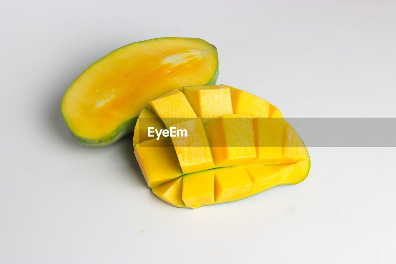 Close-up of sliced yellow  mango  against white background