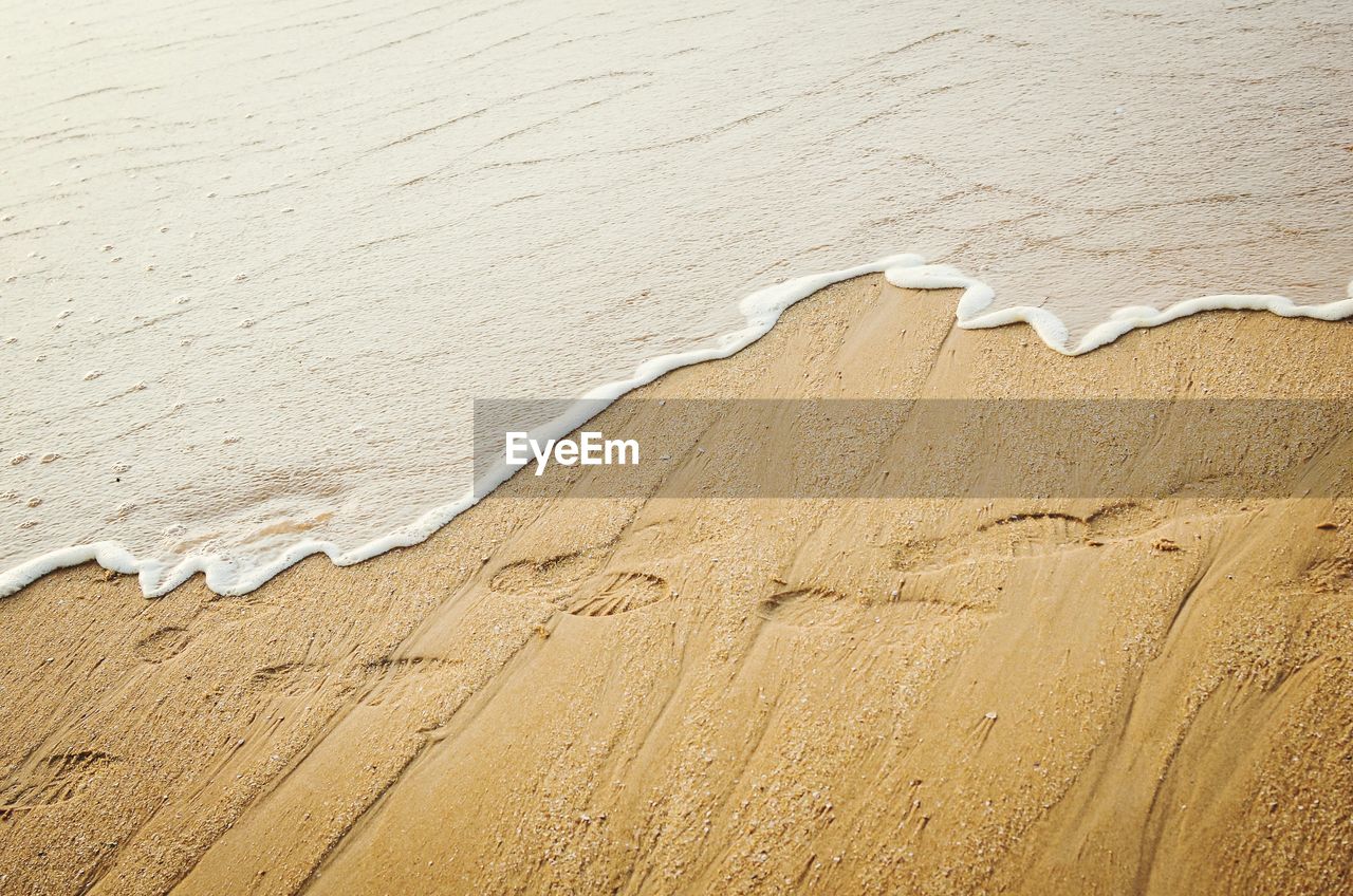 High angle view of shoeprints on beach