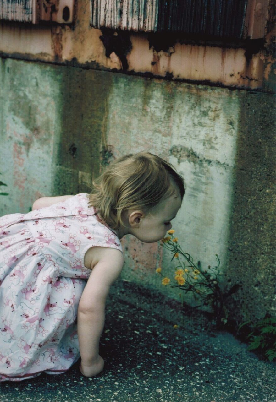 Side view of a girl smelling flower