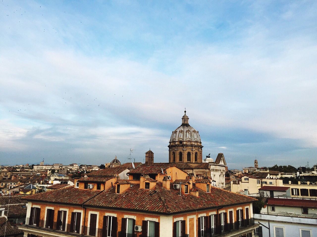 Buildings in city against cloudy sky