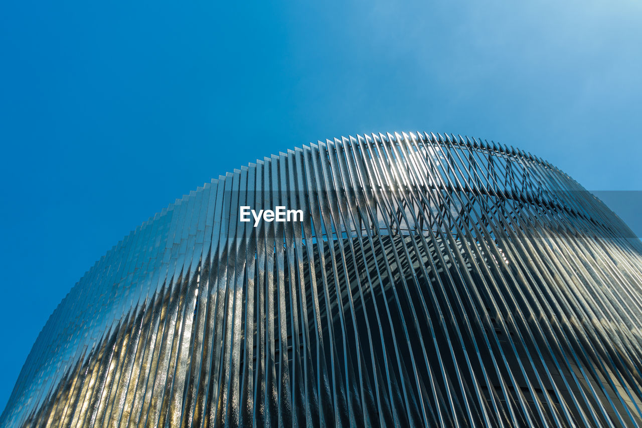 Low angle view of modern building against blue sky