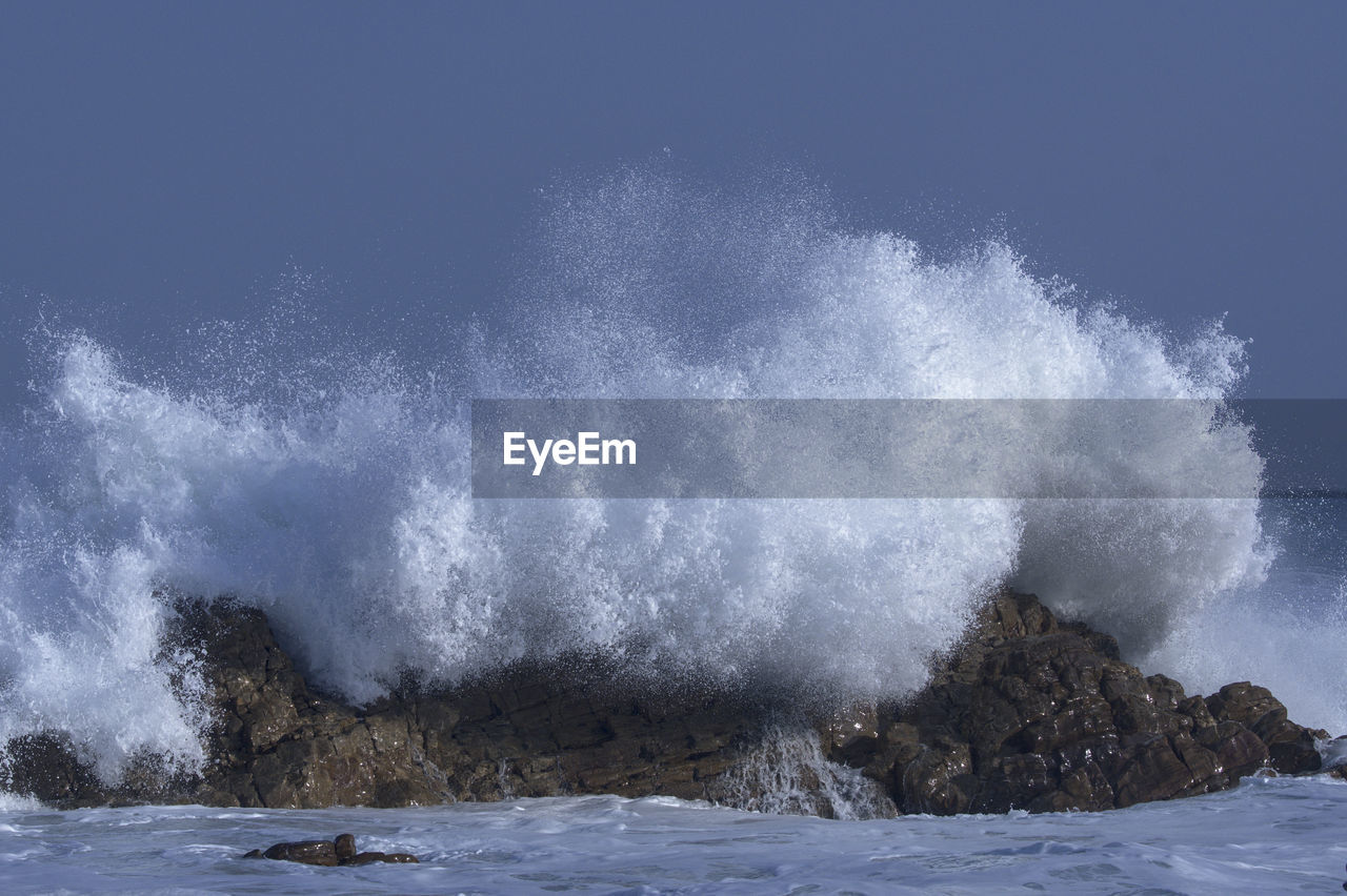 VIEW OF WAVES BREAKING ON SHORE