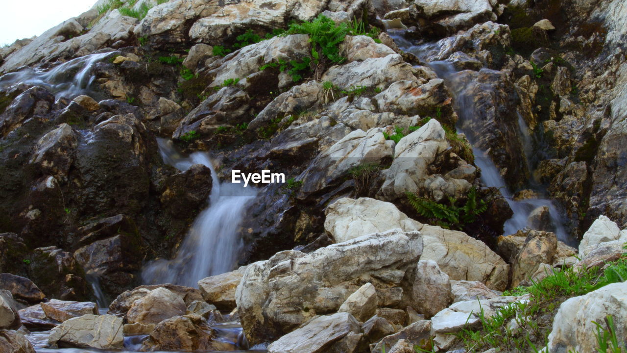 VIEW OF WATERFALL ALONG ROCKS