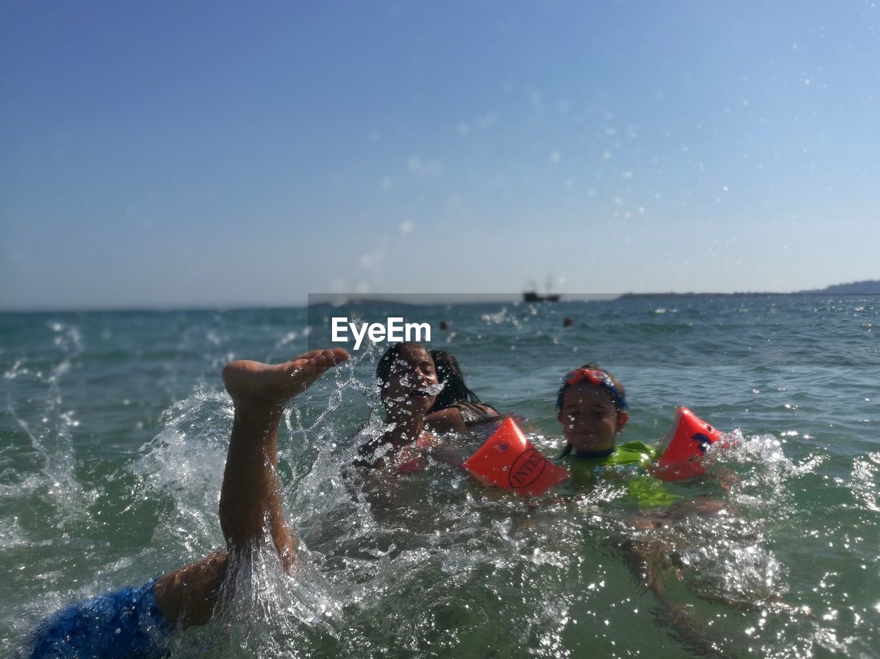 YOUNG MAN SPLASHING WATER IN SEA