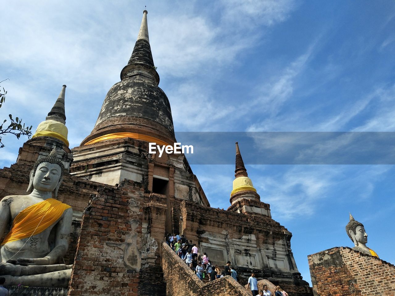 Low angle view of people at old temple against sky