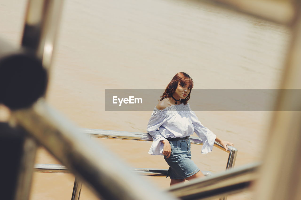 Young woman seen through railing