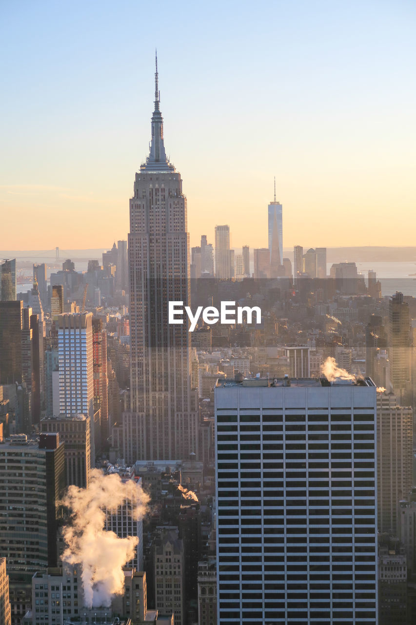 Cityscape against clear sky during sunset