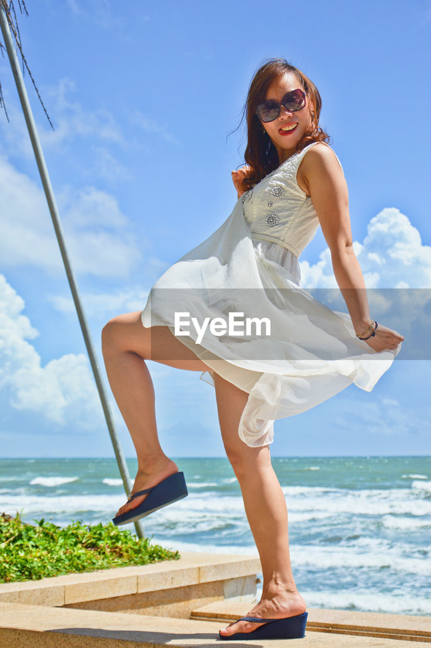 Portrait of young woman dancing on beach