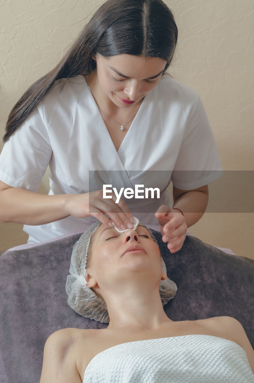 Woman cleaning customer face