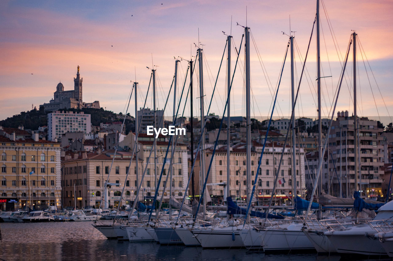 Sailboats in city at sunset